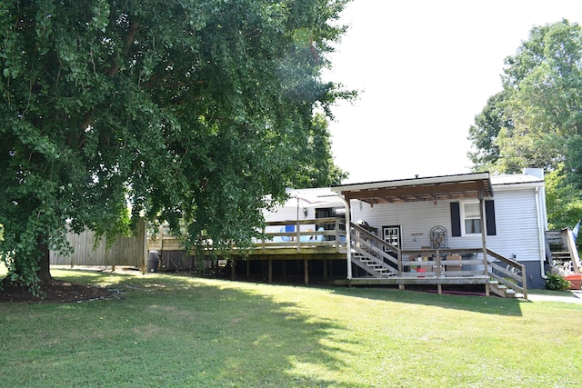 back of property with a wooden deck and a lawn