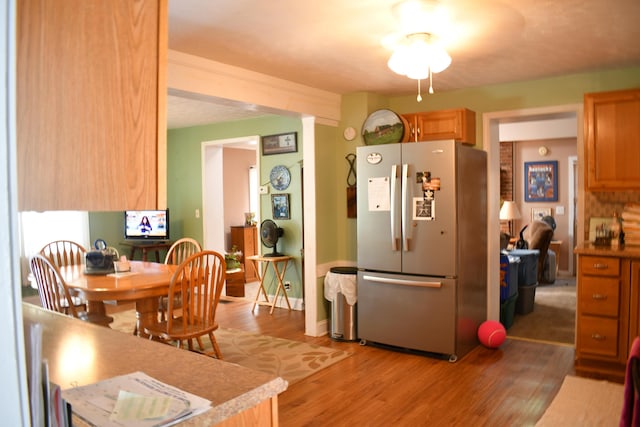 kitchen featuring stainless steel refrigerator and light hardwood / wood-style flooring