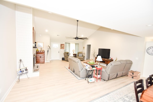 living room with lofted ceiling, ceiling fan, and light wood-type flooring