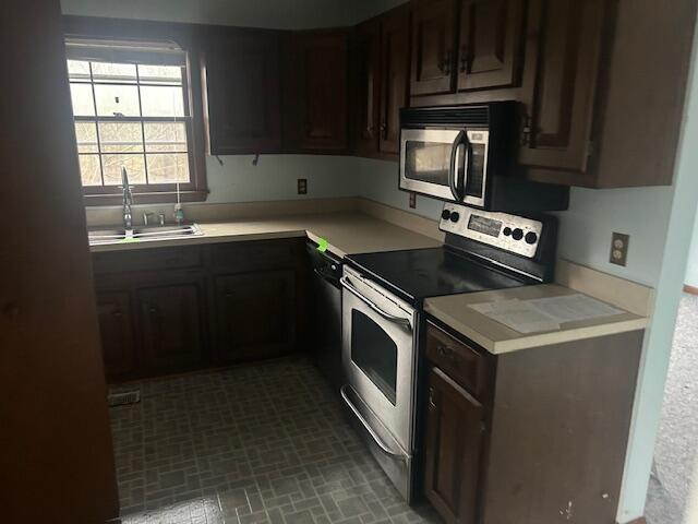 kitchen with stainless steel appliances, sink, and dark brown cabinets