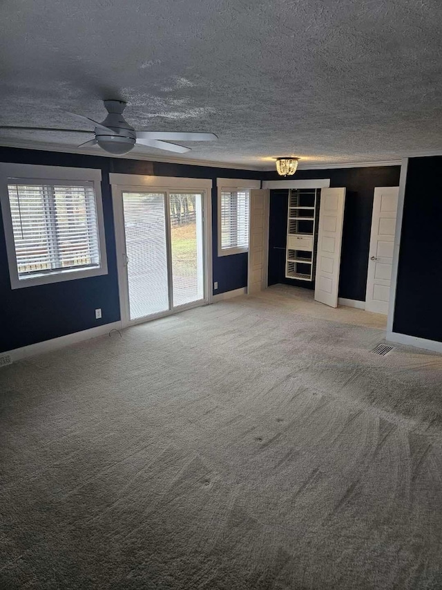 unfurnished living room featuring ceiling fan, carpet floors, and a textured ceiling