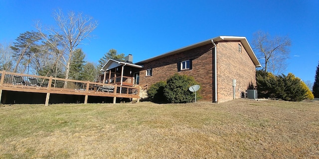 rear view of property with central AC, a lawn, and a deck