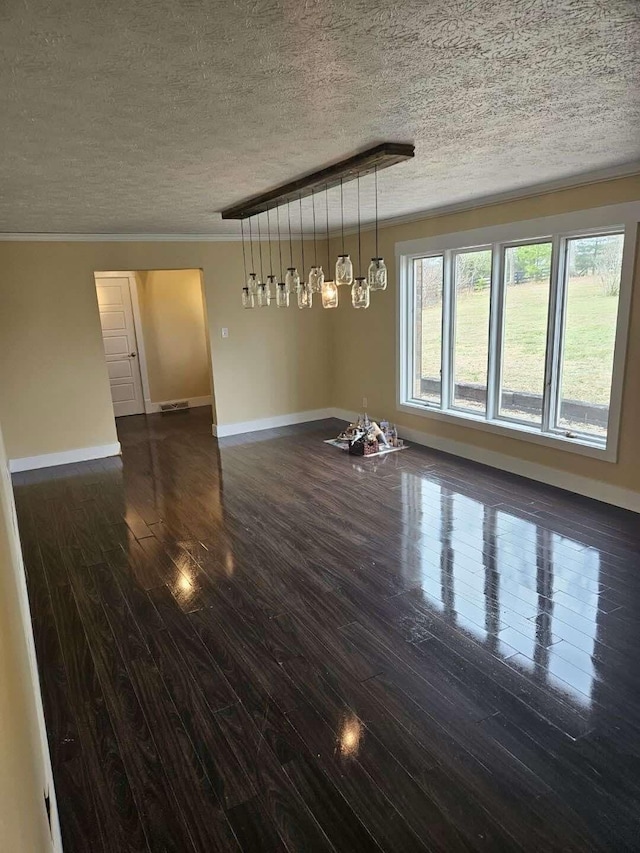 empty room with ornamental molding, dark wood-type flooring, and a textured ceiling