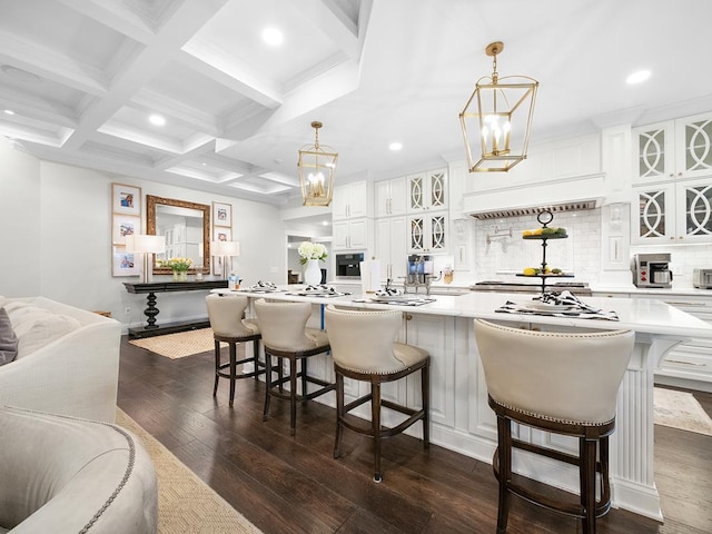 kitchen featuring white cabinetry, a breakfast bar, a notable chandelier, and a large island