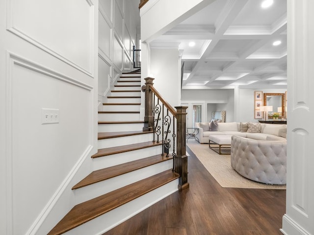 stairs featuring crown molding, coffered ceiling, hardwood / wood-style floors, and beam ceiling