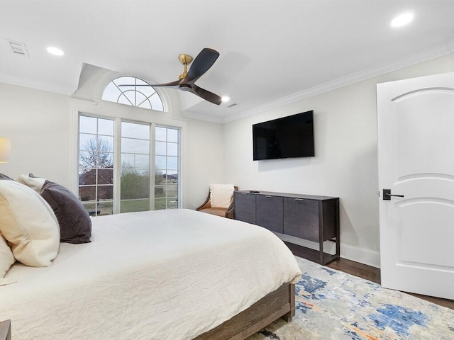 bedroom featuring dark hardwood / wood-style flooring, ornamental molding, and ceiling fan