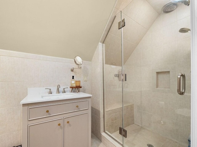 bathroom featuring vaulted ceiling, tile walls, vanity, and walk in shower