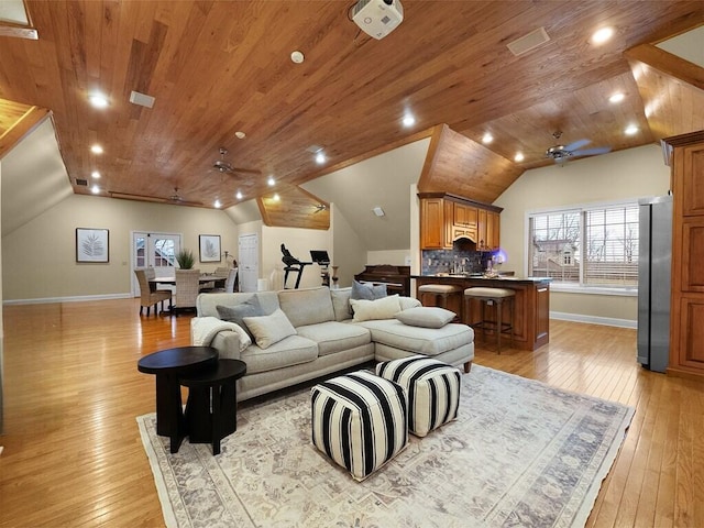 living room featuring ceiling fan, vaulted ceiling, and light hardwood / wood-style flooring