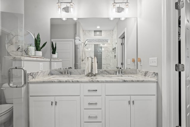 bathroom with vanity, a shower with shower door, and toilet