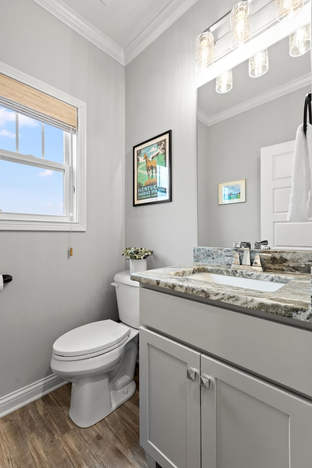 bathroom with vanity, hardwood / wood-style floors, crown molding, and toilet