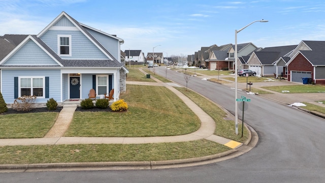 view of front of house featuring a garage, a front lawn, and covered porch