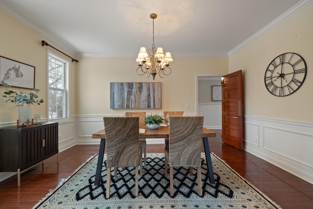 dining room featuring ornamental molding, dark wood-type flooring, and an inviting chandelier