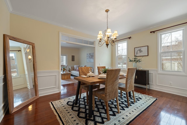 dining room featuring an inviting chandelier, ornamental molding, and dark hardwood / wood-style flooring