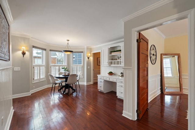 dining space featuring built in desk, ornamental molding, and dark hardwood / wood-style floors