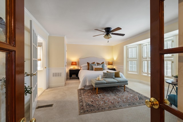 carpeted bedroom featuring crown molding and ceiling fan