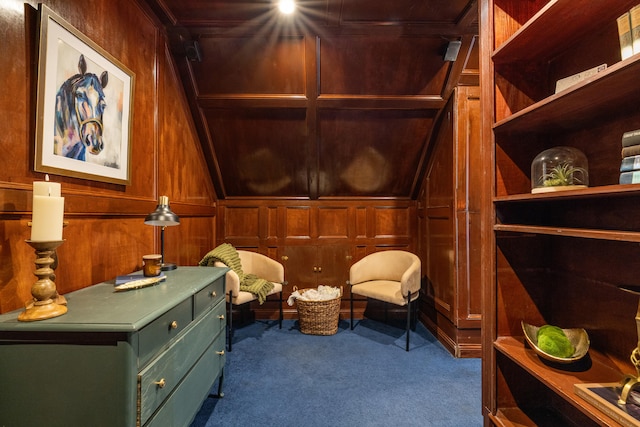 sitting room featuring wooden walls and carpet flooring