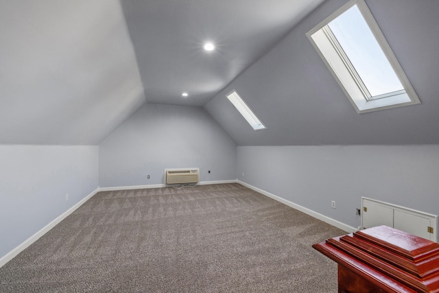 additional living space with lofted ceiling with skylight, an AC wall unit, and carpet floors