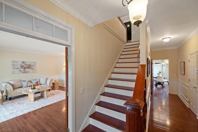 staircase featuring hardwood / wood-style floors and crown molding