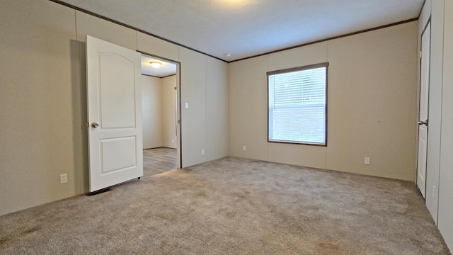 unfurnished bedroom featuring ornamental molding and light colored carpet