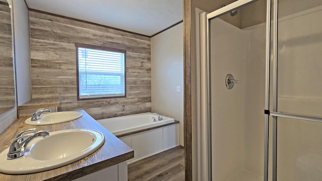 bathroom featuring plus walk in shower, wooden walls, hardwood / wood-style flooring, ornamental molding, and vanity