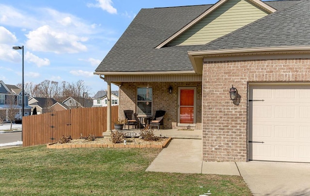 property entrance featuring a garage, a yard, and a porch