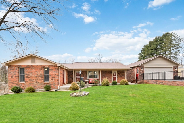 ranch-style home featuring a garage, covered porch, and a front yard