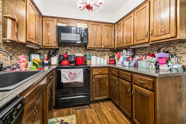 kitchen with sink, backsplash, black appliances, a textured ceiling, and light hardwood / wood-style flooring