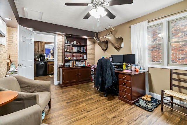 office featuring ceiling fan, brick wall, and light hardwood / wood-style floors