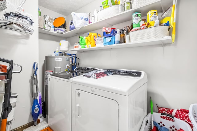 laundry area with electric water heater, washer and dryer, and a textured ceiling