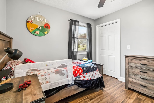 bedroom with wood-type flooring, ceiling fan, and a closet