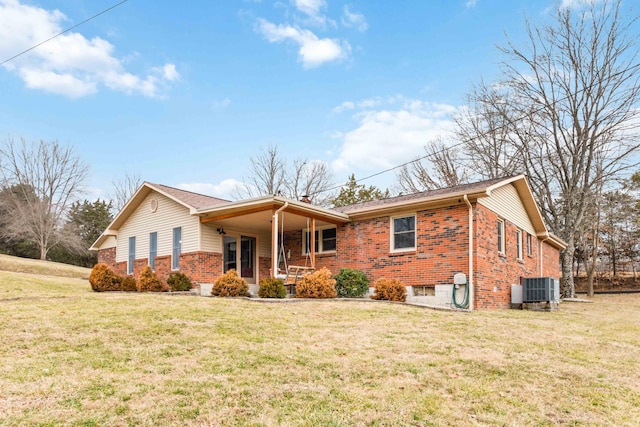 view of front of home featuring cooling unit, a front yard, and covered porch