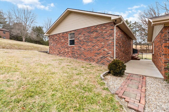 view of side of property featuring a patio and a yard