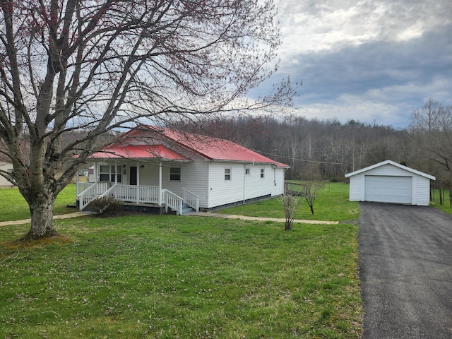 view of front of home with a front yard, an outdoor structure, a porch, and driveway