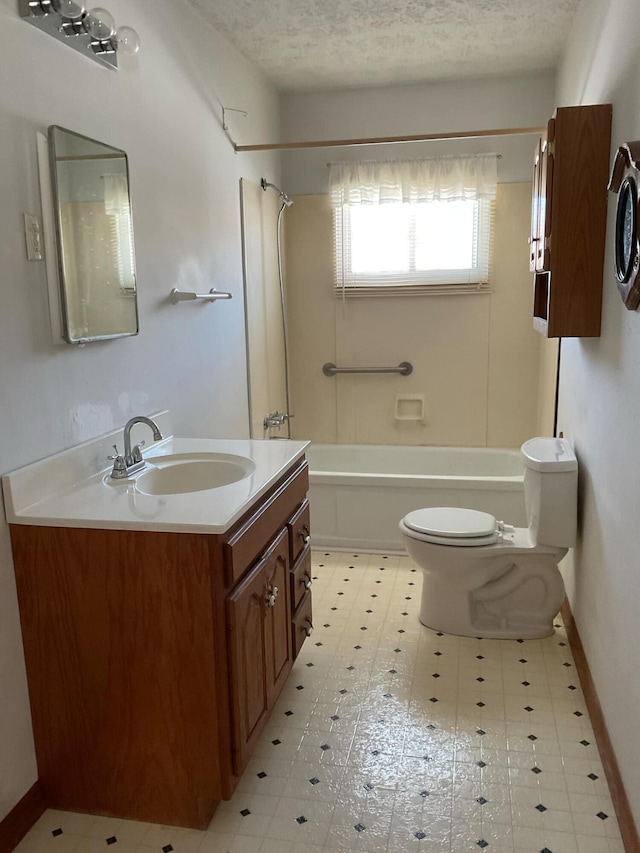 bathroom featuring vanity, toilet, baseboards, a textured ceiling, and  shower combination