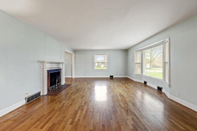 unfurnished living room featuring hardwood / wood-style flooring and a fireplace