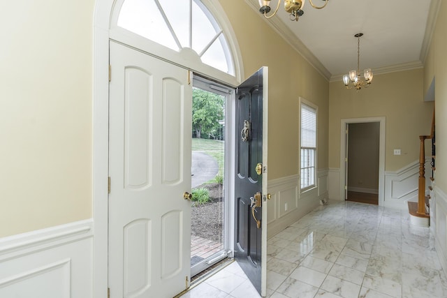 entrance foyer featuring an inviting chandelier and crown molding