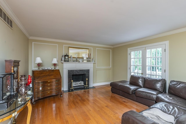 living room featuring crown molding, a fireplace, and hardwood / wood-style floors