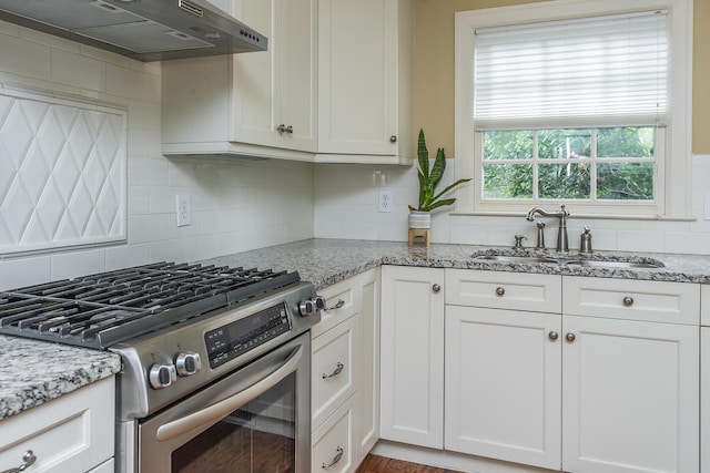 kitchen featuring sink, light stone countertops, and gas stove