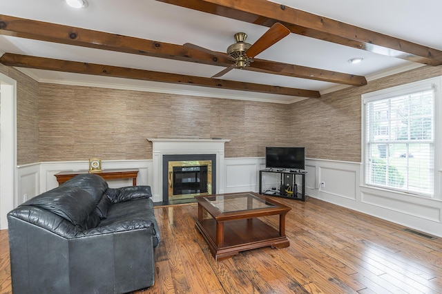 living room with wood-type flooring, ceiling fan, and beam ceiling