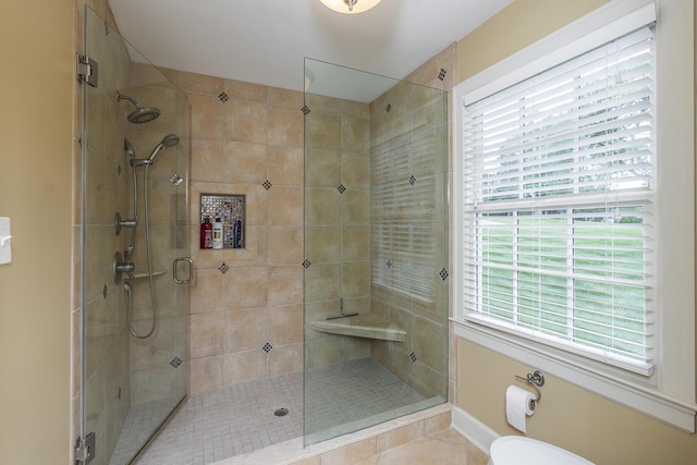 bathroom featuring a shower with shower door and toilet