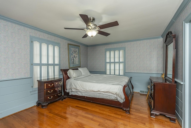 bedroom featuring crown molding, ceiling fan, and light wood-type flooring