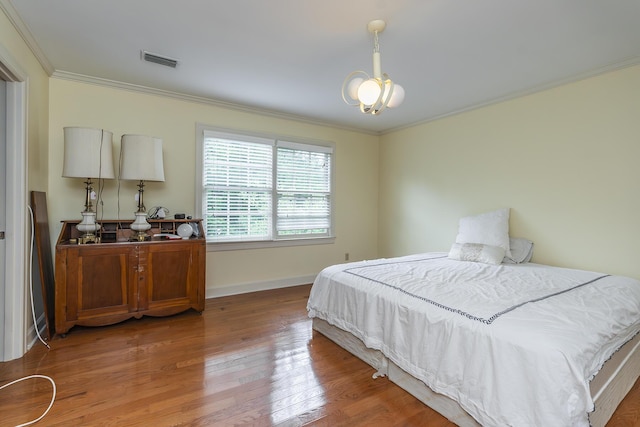 bedroom featuring ornamental molding and hardwood / wood-style floors