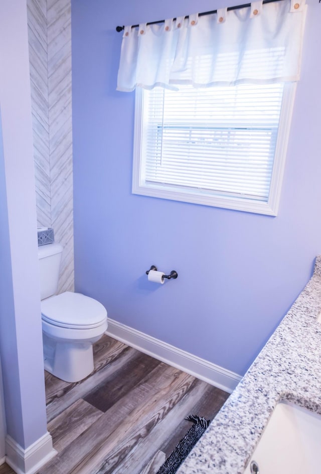 bathroom featuring wood-type flooring, vanity, and toilet