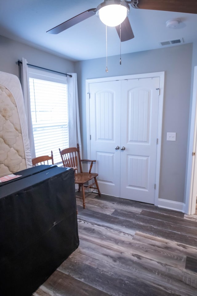 bedroom with ceiling fan, dark hardwood / wood-style flooring, and a closet