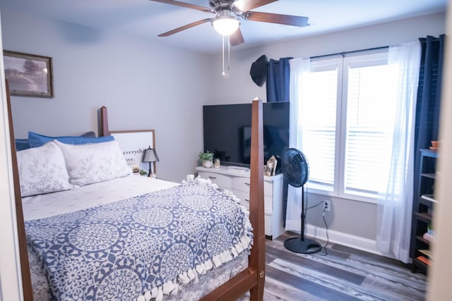 bedroom with ceiling fan, dark hardwood / wood-style floors, and multiple windows