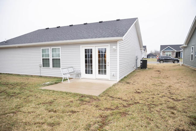 rear view of house with a patio, a yard, and central AC