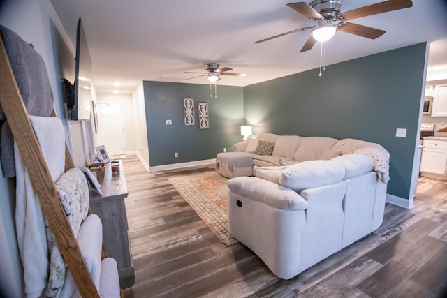 living room featuring ceiling fan and dark hardwood / wood-style flooring