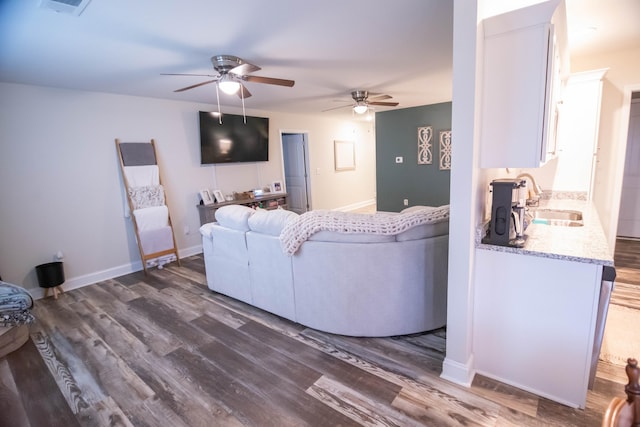 living room with ceiling fan, dark hardwood / wood-style flooring, and sink