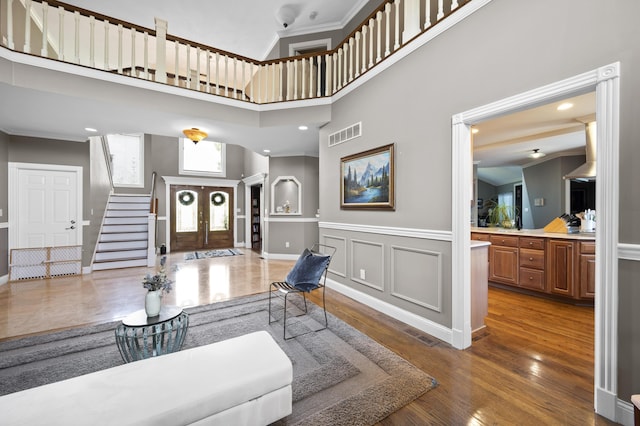 living room with french doors, ornamental molding, dark hardwood / wood-style floors, and a towering ceiling