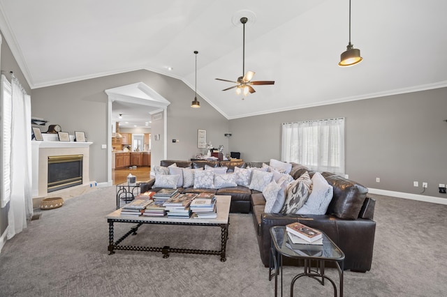 living room featuring vaulted ceiling, ornamental molding, ceiling fan, and carpet flooring